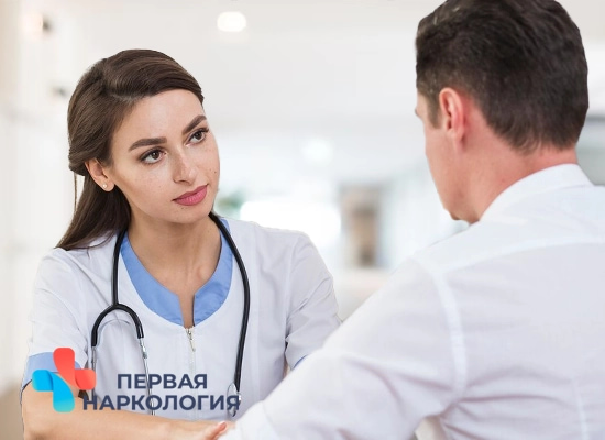 Врач общается с пациентом за столом